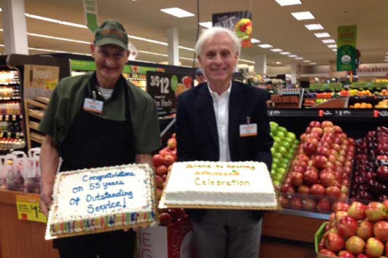 Store Director Jim Burns, right, congratulates employee Mike Mezzadri, who has worked for Shaw’s for 55 years.