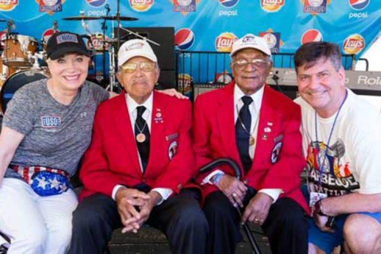 Elaine Rogers, president of USO of Metropolitan Washington-Baltimore, and Gordon Reid, president of Giant Food of Landover, right, celebrate the opening of the 25th Annual Giant National Capital Barbecue Battle with Walter Robinson Jr. and William Fauntroy Jr., two Tuskegee Airmen who served during World War II.