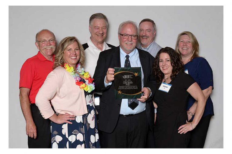 Larrry Baker, center, celebrates his Vendor of the Year award with fellow Bunzl employees Rick Sorenson, Shannon Parker, Bob Hensen, Mike Barhart, Trina Valdez and Lisa McNeeley. (Photo © 2018 CJ Photo NW)