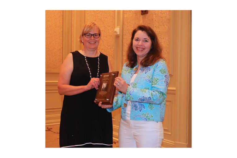 Andrea Gold accepting the award from FMI's Jennifer Hatcher.
