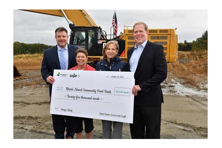 Four people at the groundbreaking ceremony hold a large check.