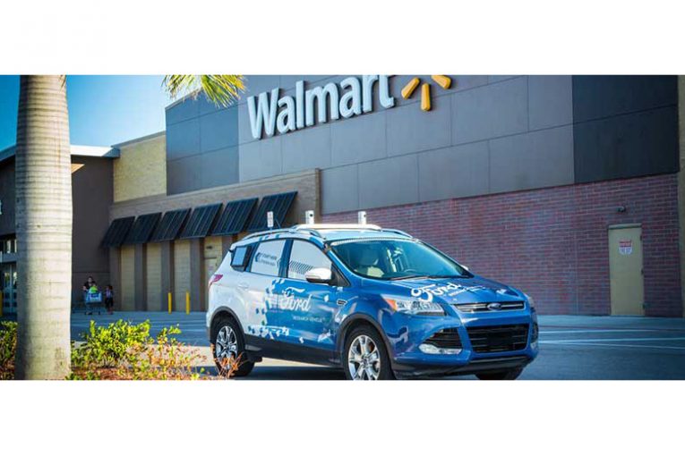 A driverless Ford car in front of a Walmart