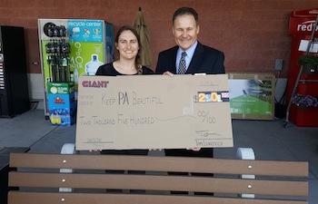 Giant Carlisle President Tom Lenkevich presents a check and bench to Shannon Reiter, president of Keep Pennsylvania Beautiful.